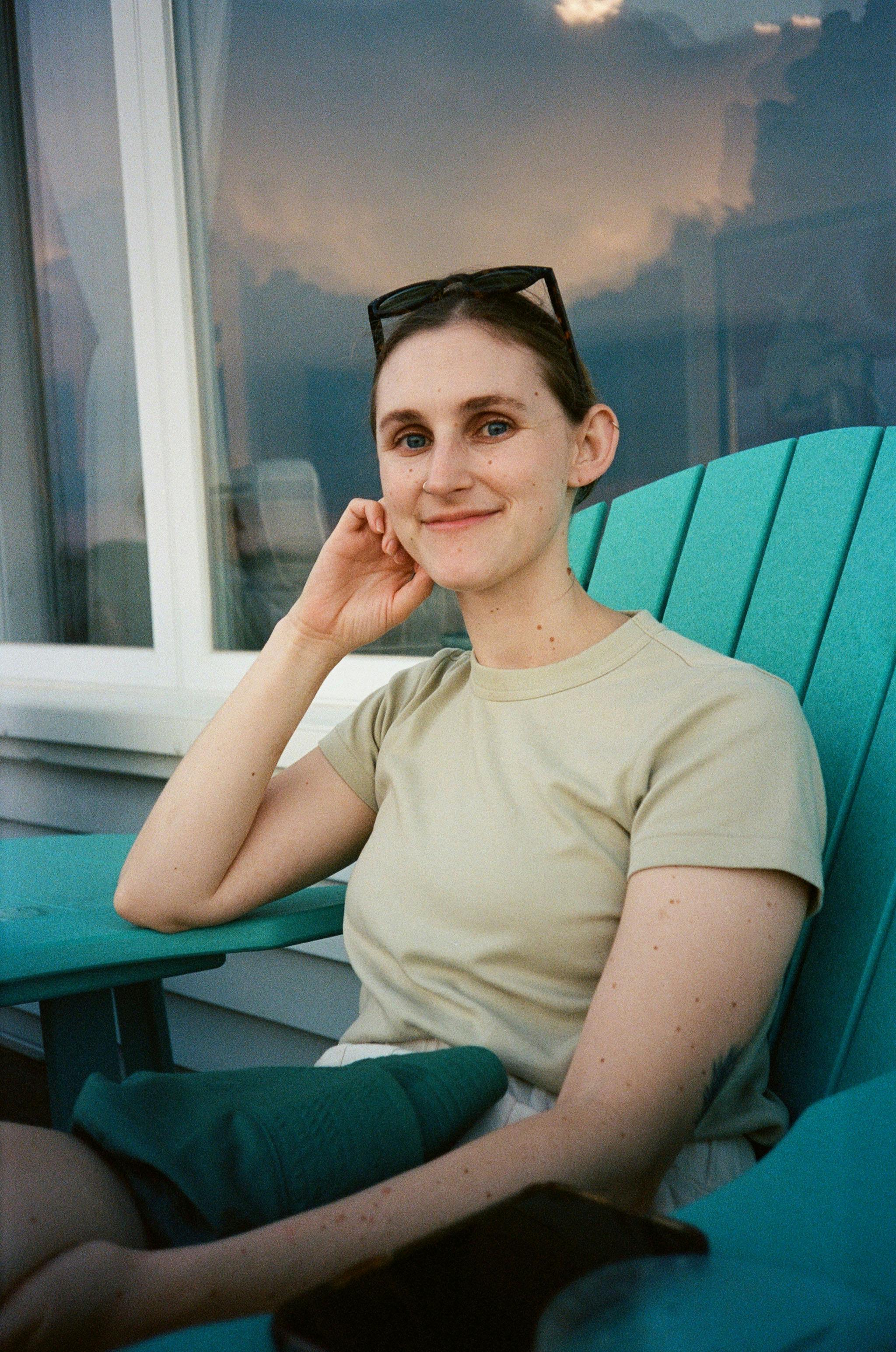 a portrait of Paige Williams sitting in a deck chair in front of a house